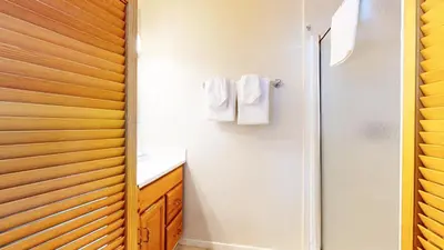 a bathroom with white walls and a wooden door at Sierra Manors #75 Condo in Mammoth Lakes