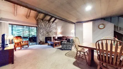 a living room with a table and chairs and a fireplace at Snowcreek I #82 Condo in Mammoth Lakes
