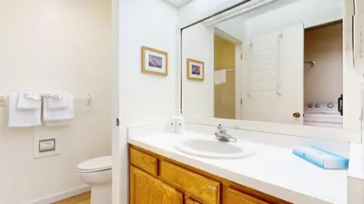 a bathroom with a sink and a toilet and a mirror at Snowcreek I #82 Condo in Mammoth Lakes