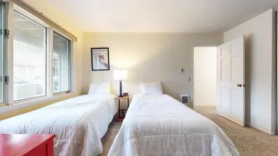 two beds in a room with a window at Chateau De Montagne #24 Condo in Mammoth Lakes