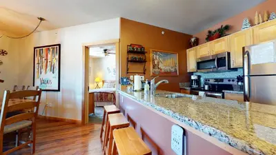a kitchen with a counter with a sink and a refrigerator at Juniper Springs Lodge #539 Condo in Mammoth Lakes