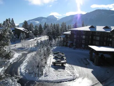a group of cars parked in the snow in front of a hotel at Juniper Springs Lodge #539 Condo in Mammoth Lakes