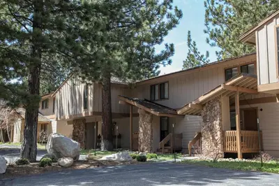 a house with trees in front of it at Condo de los Pinos #16 in Mammoth Lakes