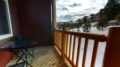 a balcony with a table and a chair and a window at Sunstone #214 Condo in Mammoth Lakes