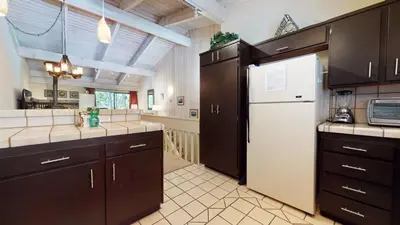 a kitchen with brown cabinets and a white refrigerator at Mammoth West #106 Condo in Mammoth Lakes