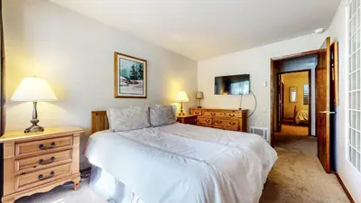 a bedroom with a bed and a dresser and a television at Mammoth West #106 Condo in Mammoth Lakes