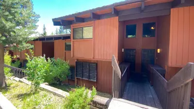 a house with a wooden walkway in front of it at Mammoth West #106 Condo in Mammoth Lakes