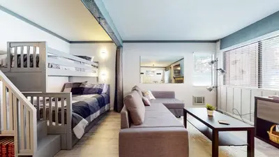 a bedroom with a bunk bed and a couch at Mammoth Ski & Racquet Club #4 Condo in Mammoth Lakes