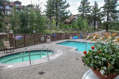 a small swimming pool with flowers in a yard at Sunstone #127 Condo in Mammoth Lakes