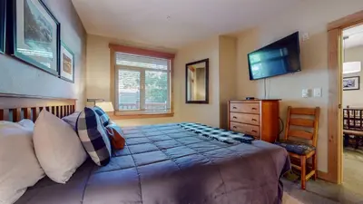 a bedroom with a bed and a dresser and a television at Sunstone #114 Condo in Mammoth Lakes