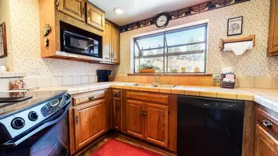 a kitchen with wooden cabinets and a sink and a window at Snowflower #81 Condo in Mammoth Lakes