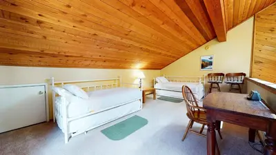 a living room with white furniture and wooden ceilings at Snowflower #81 Condo in Mammoth Lakes