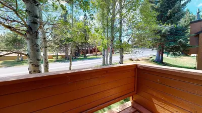 a wooden fence with trees in the background at Snowflower #81 Condo in Mammoth Lakes