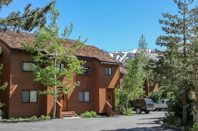 a house with a mountain in the background at Snowflower #81 Condo in Mammoth Lakes