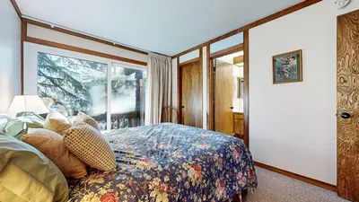 a bedroom with a bed and a large window at Mammoth West #111 Condo in Mammoth Lakes
