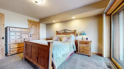 a bedroom with a bed and a dresser and a window at Bridges Townhome #15 Condo in Mammoth Lakes