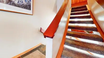 a staircase in a building with a red rail at Bridges Townhome #15 Condo in Mammoth Lakes