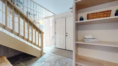a hallway with a staircase and a door at Mammoth West #115 Condo in Mammoth Lakes