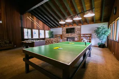 a ping pong table in a living room with at Mammoth West #101 Condo in Mammoth Lakes