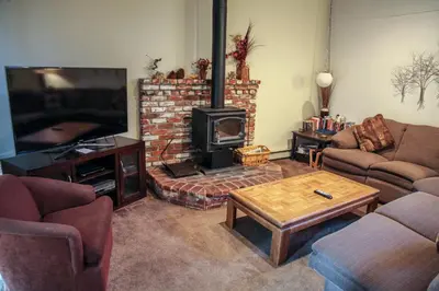 a living room with a fireplace and a tv at Chateau De Montagne #3 Condo in Mammoth Lakes