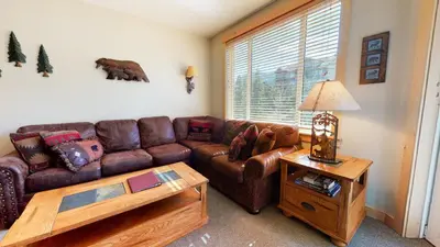 a living room with a brown leather couch and a table at Sunstone #208 Condo in Mammoth Lakes