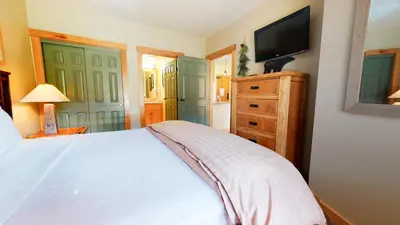 a bedroom with a white bed and a television at Sunstone #208 Condo in Mammoth Lakes