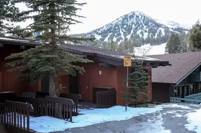 a building with a tree in front of it in the snow at Mammoth West #137 Condo in Mammoth Lakes