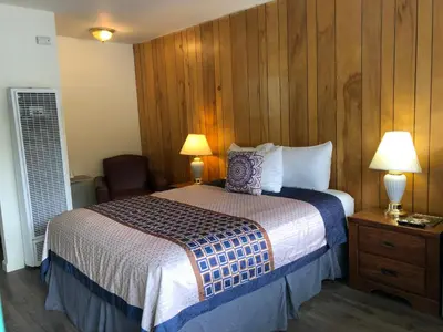 a hotel room with a bed and two lamps at Cedar Inn & Suites in South Lake Tahoe