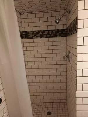 a bathroom with a shower with black and white tiles at Cedar Inn & Suites in South Lake Tahoe