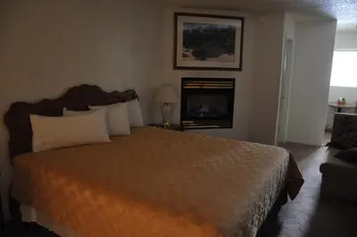 a hotel room with a bed and a fireplace at Cedar Inn & Suites in South Lake Tahoe