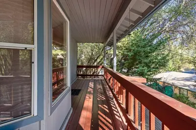a porch of a house with a view of the trees at Yosemite Falls Calling in Groveland