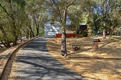 a path in a park with a tree and a slide at Yosemite Falls Calling in Groveland