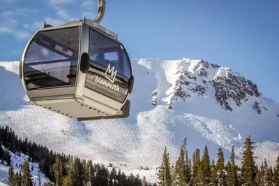 a ski lift with a snow covered mountain in the background at Mammoth Ski & Racquet Club #131 in Mammoth Lakes