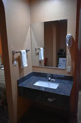 a bathroom with a sink and a mirror at Apex Inn in Modesto