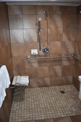 a bathroom with a shower with a toilet and a sink at Apex Inn in Modesto