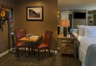 a hotel room with a bed and a desk with a bed and a bed at Postmarc Hotel and Spa Suites in South Lake Tahoe