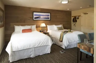 a hotel room with two beds and a table at Postmarc Hotel and Spa Suites in South Lake Tahoe