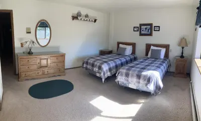 a bedroom with two beds and a dresser and a mirror at House on Cold Creek in South Lake Tahoe