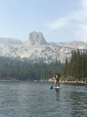 a man riding a paddle board on a lake at Mountainback 48 Corner Unit in Mammoth Lakes