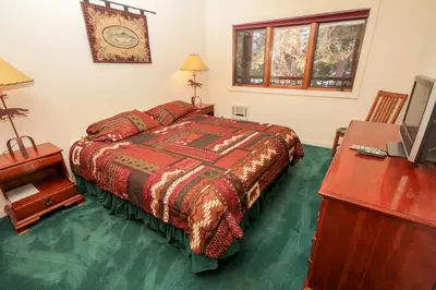 a bedroom with a bed and a desk and a television at Mountainback 41 Loft in Mammoth Lakes