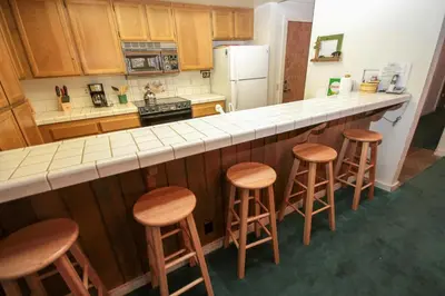 a kitchen with wooden stools and a counter top at Mountainback 41 Loft in Mammoth Lakes