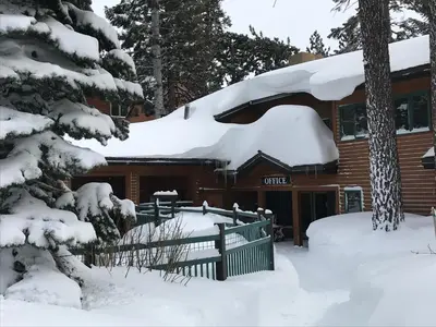 a log cabin with snow on the roof at Mountainback 40 Loft Corner in Mammoth Lakes