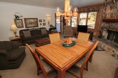 a living room with a wooden table and a fireplace at Mountainback 38 pet unit in Mammoth Lakes