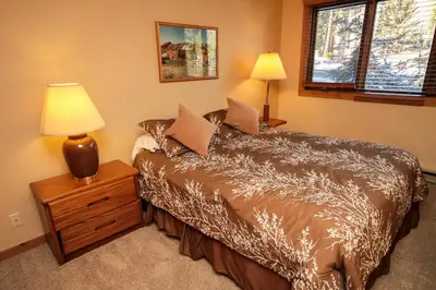 a bedroom with a bed and a lamp on a night stand at Mountainback 37 Den in Mammoth Lakes