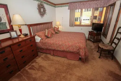 a bedroom with a bed and a dresser and a television at Mountainback 34 Corner in Mammoth Lakes