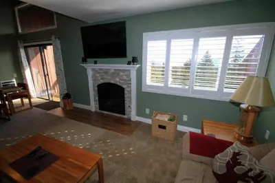 a living room with a fireplace and a flat screen tv at Mammoth Ski Racquet Club 66 in Mammoth Lakes