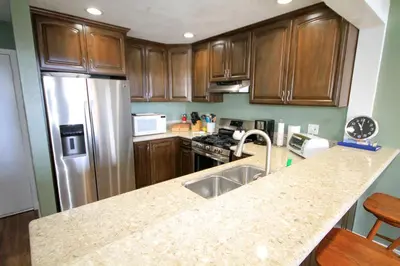 a kitchen with wooden cabinets and a stainless steel refrigerator at Mammoth Ski Racquet Club 66 in Mammoth Lakes