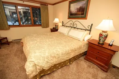a bedroom with a bed and a table with a lamp at Mountainback 49 Den in Mammoth Lakes