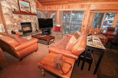 a living room with leather furniture and a stone fireplace at Mountainback 52 Loft Corner in Mammoth Lakes