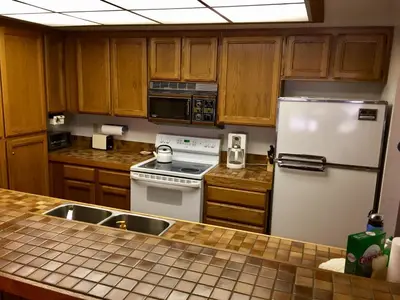 a kitchen with wooden cabinets and a white refrigerator at Mountainback #74 in Mammoth Lakes
